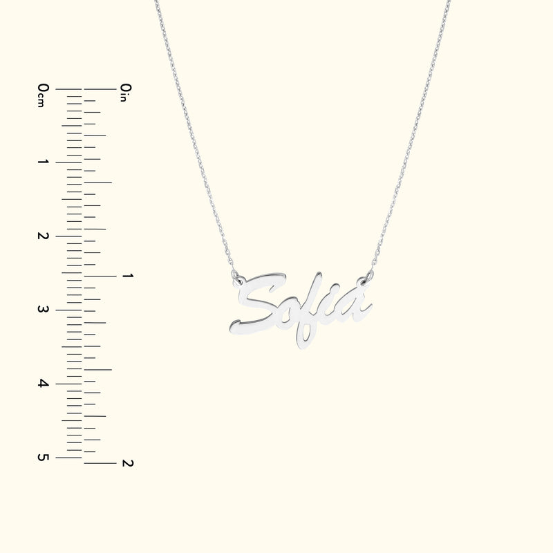 Silver necklace with the name "Sofia" in cursive lettering, displayed with a ruler for scale.