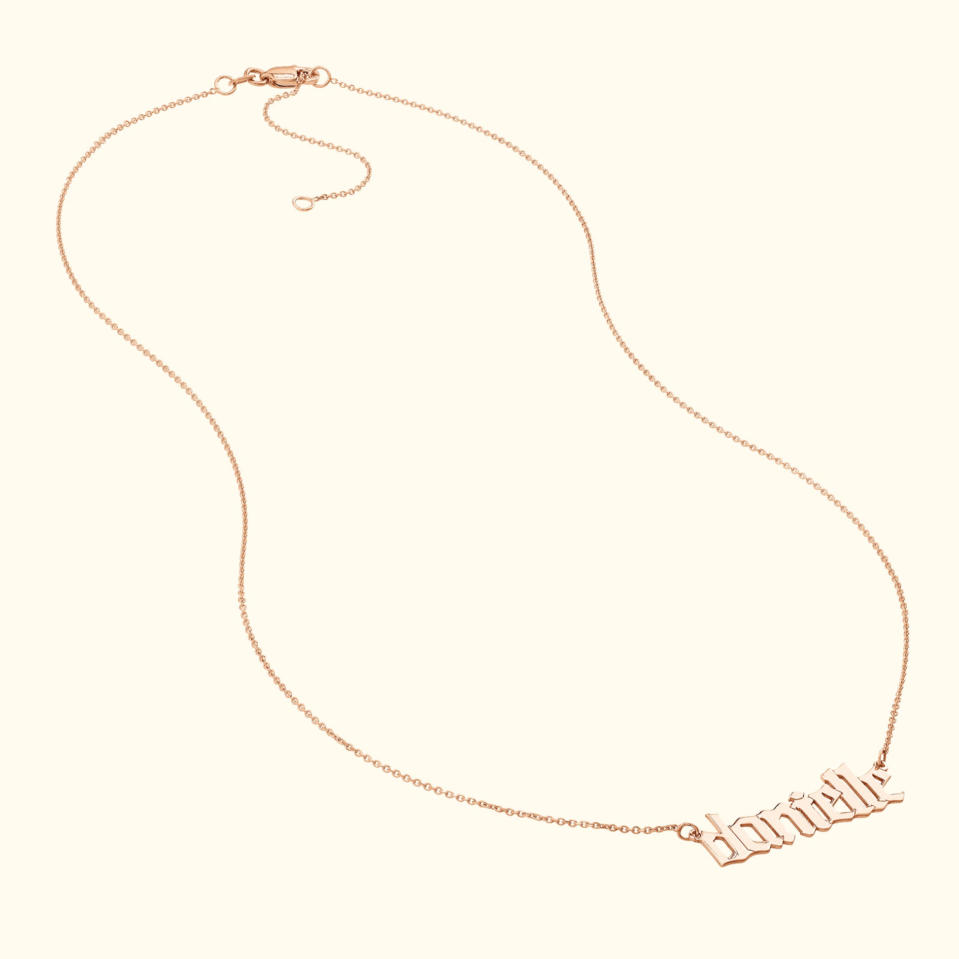 Rose gold necklace with a decorative cursive name pendant.
