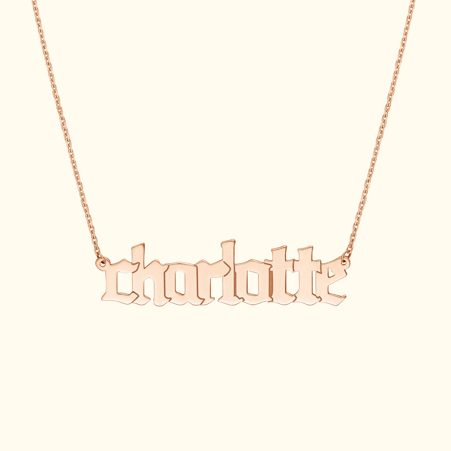 Rose gold necklace featuring the name "charlotte" in stylized lettering.