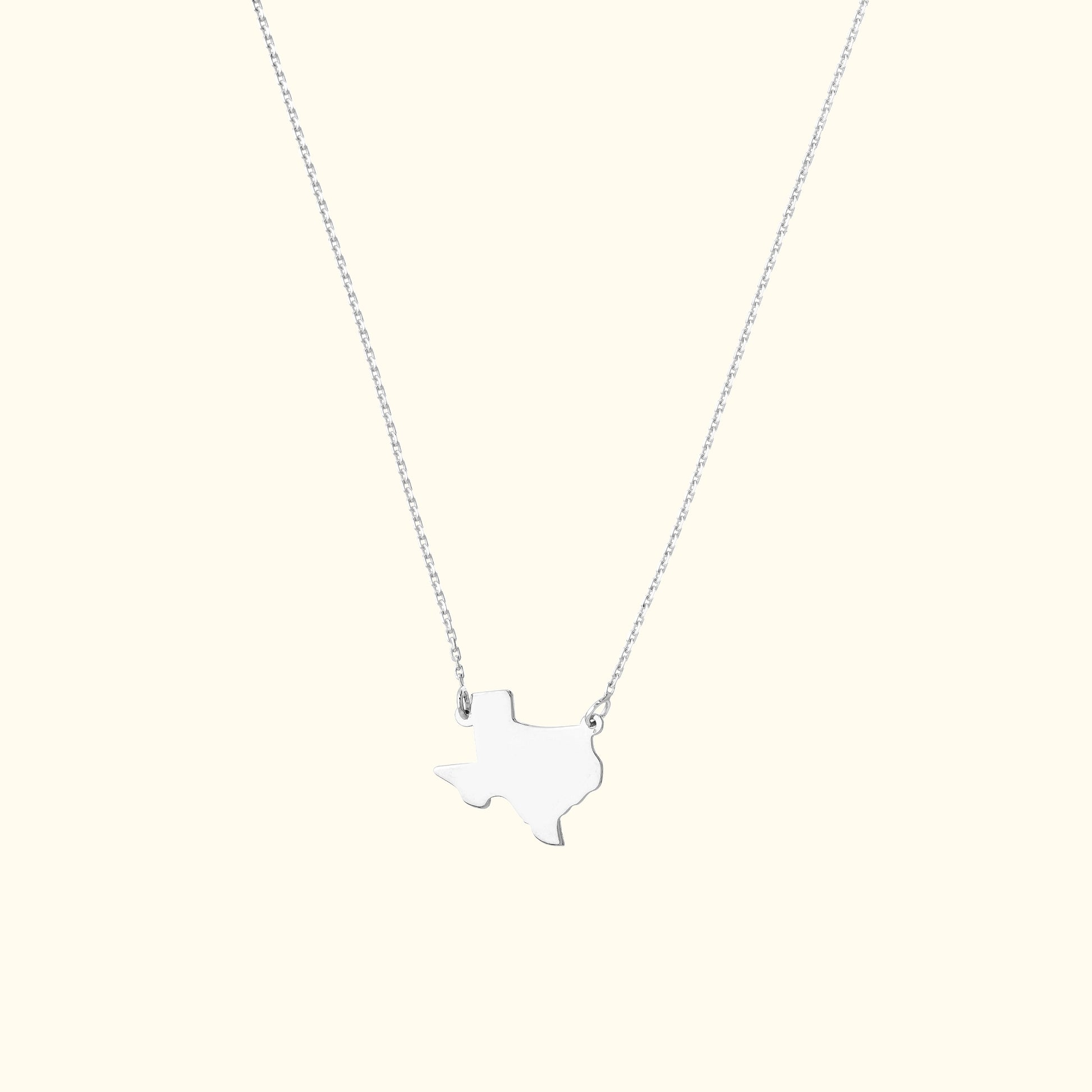 Silver necklace featuring a Texas-shaped pendant on a delicate chain.