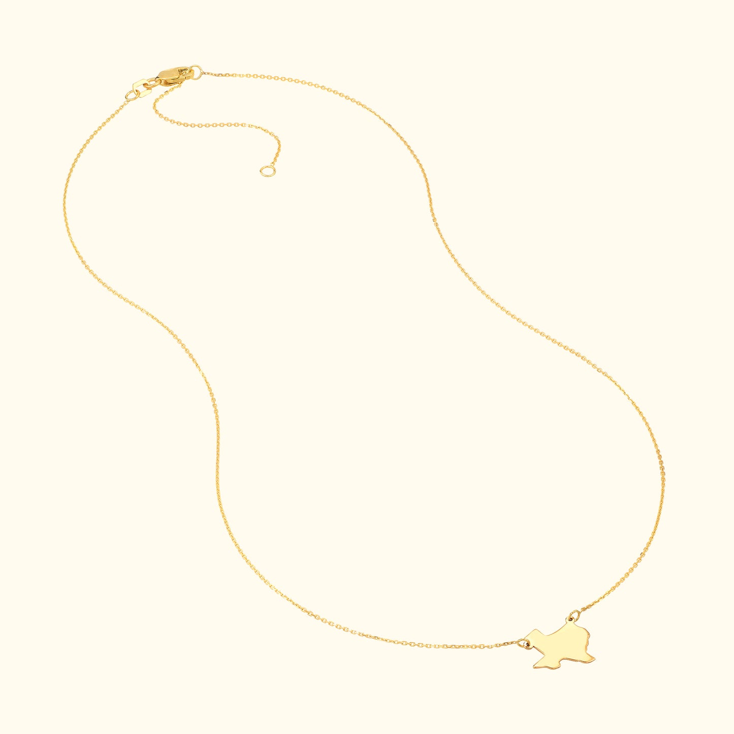 Gold necklace with a delicate chain and a small charm in the shape of a bird.