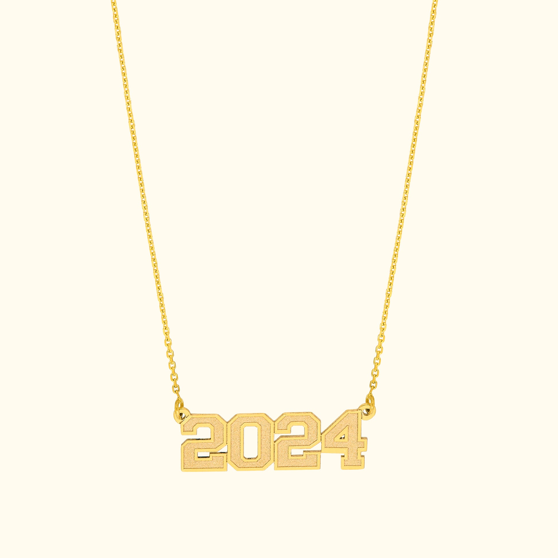 Gold necklace featuring the year "2024" as a pendant.