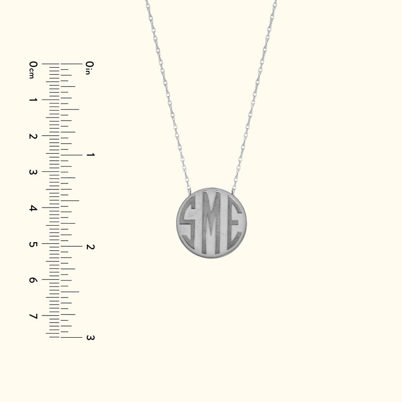 Silver pendant necklace with engraved initials "SME" on a delicate chain.