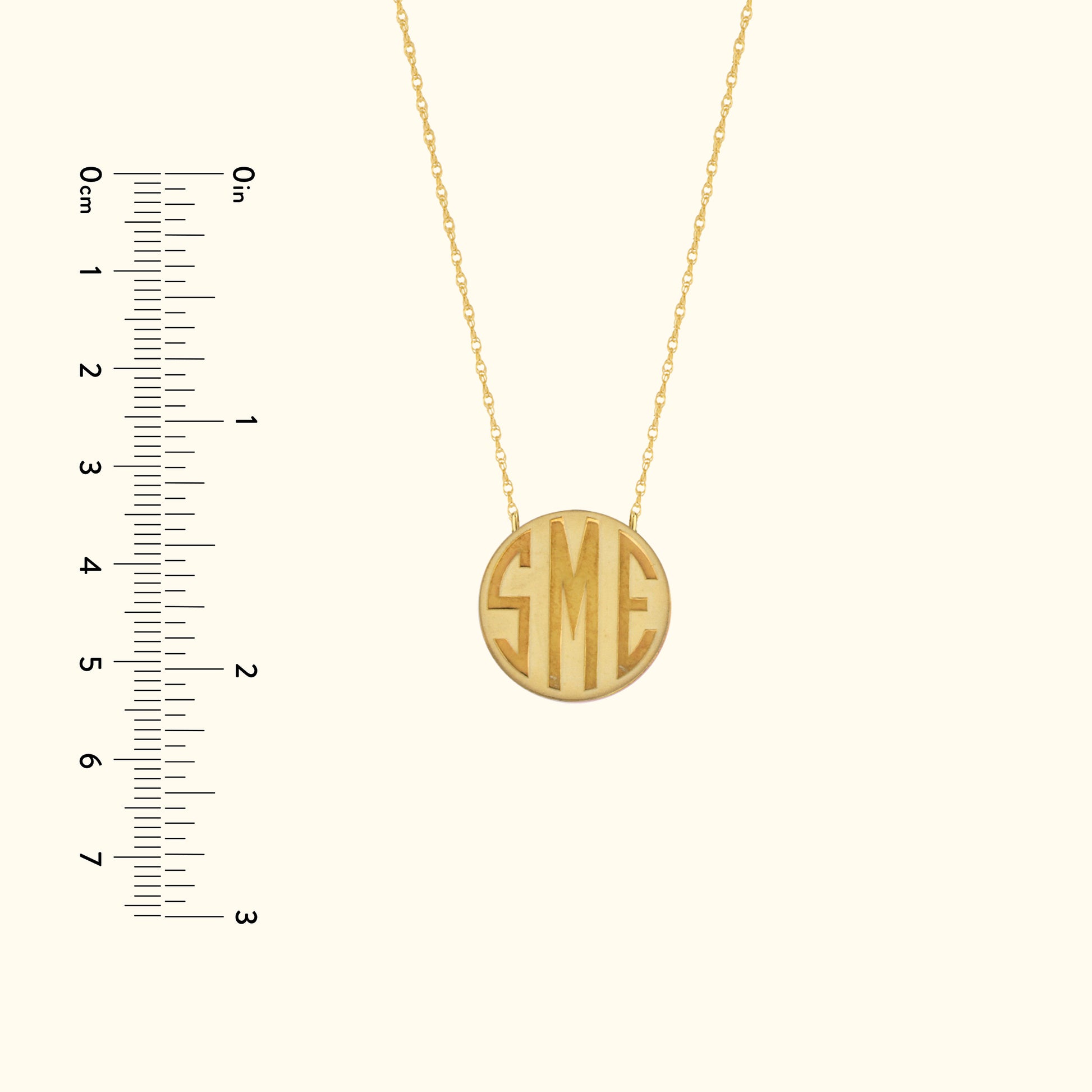 Gold pendant necklace featuring the initials "SME" in a circular design.