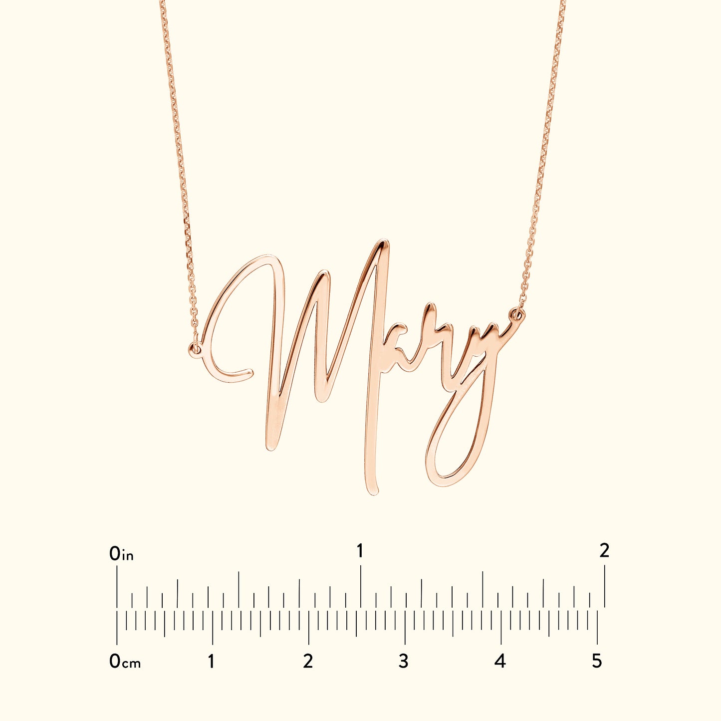 Rose gold name necklace reading "Mary" with a measuring scale below.