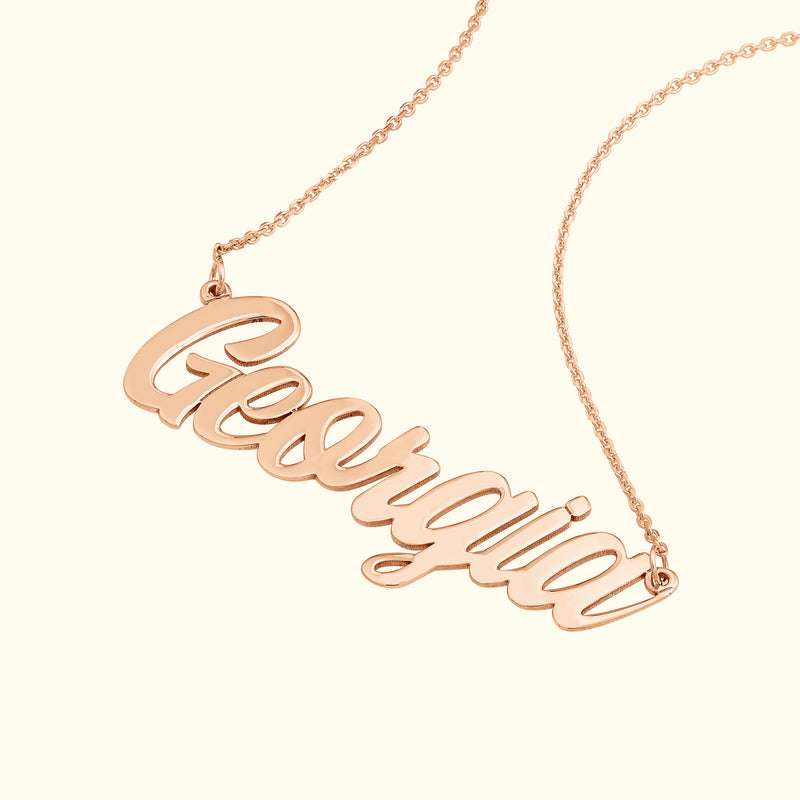 Rose gold necklace featuring a cursive nameplate that reads "Georgia."