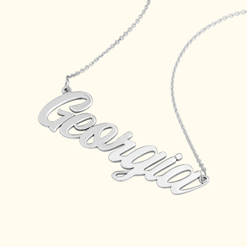 Silver name necklace with the word "Georgia" in a cursive font.
