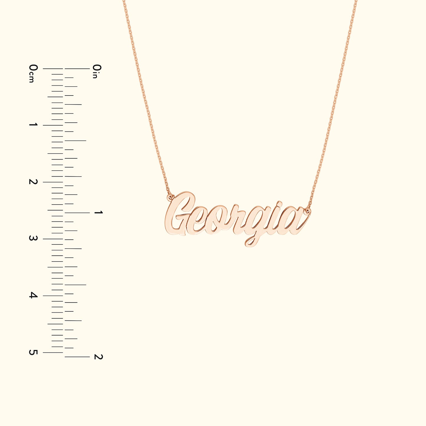Rose gold name necklace displaying the word "Georgia", with a ruler for size reference.