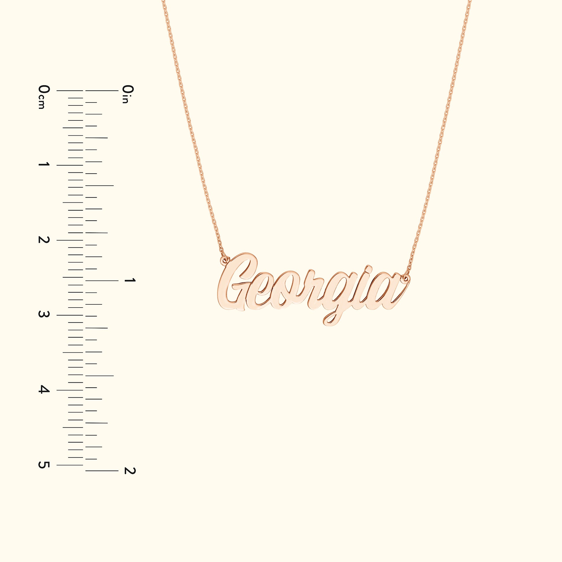 Rose gold name necklace displaying the word "Georgia", with a ruler for size reference.