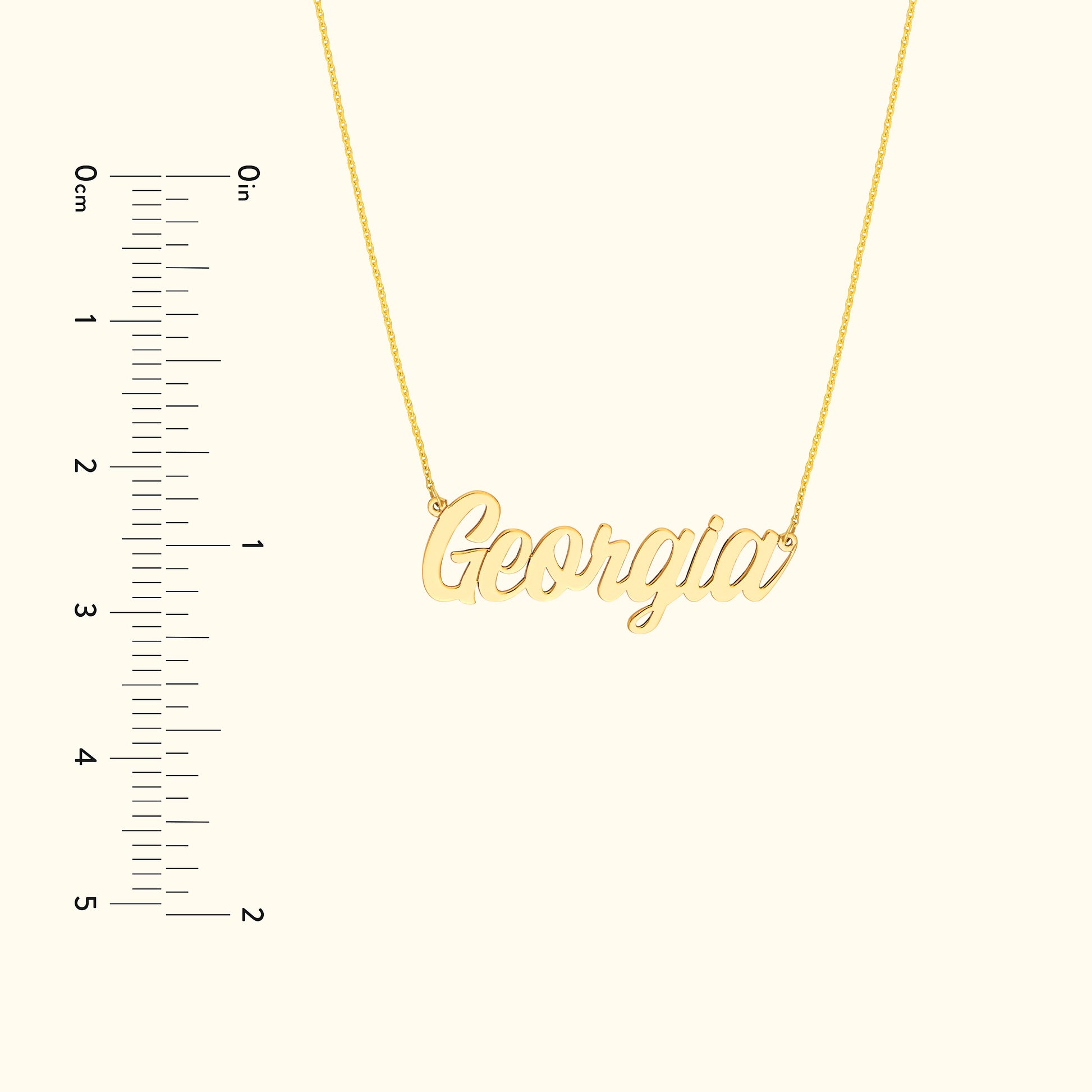 Gold name necklace depicting "Georgia" against a neutral background with a measurement scale.