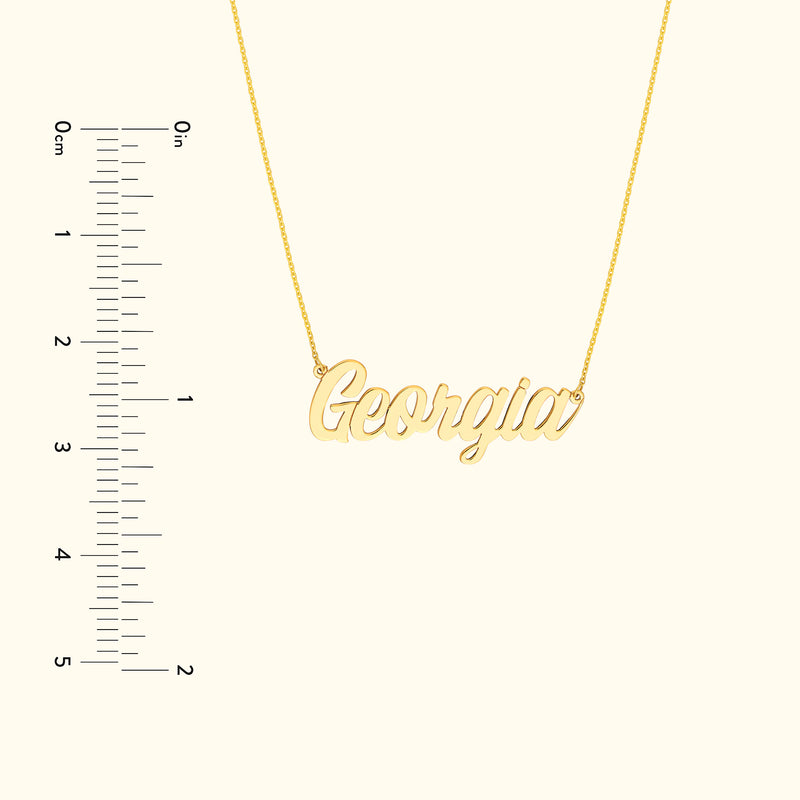 Gold name necklace depicting "Georgia" against a neutral background with a measurement scale.