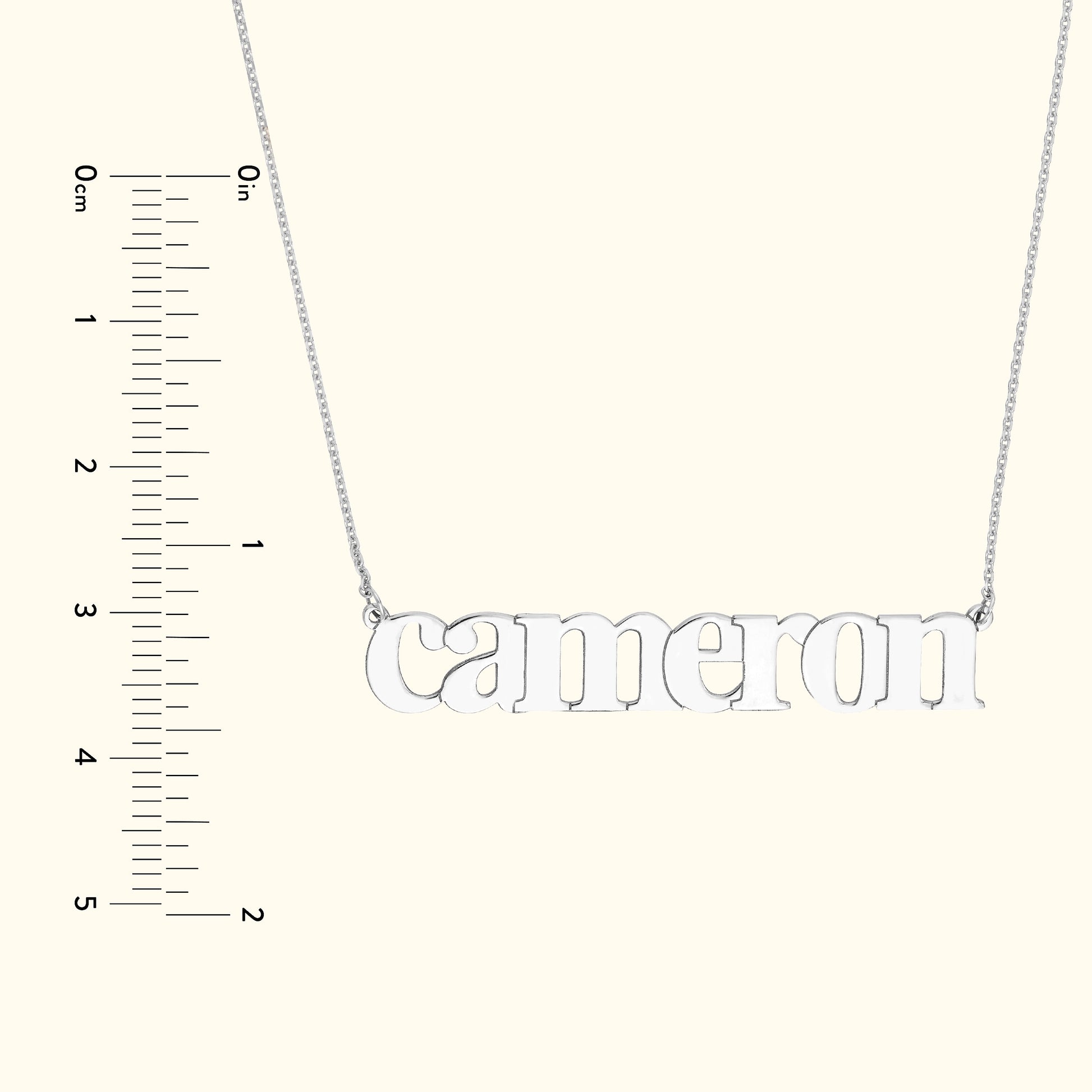 Silver name necklace displaying "Cameron" with a ruler for size reference.