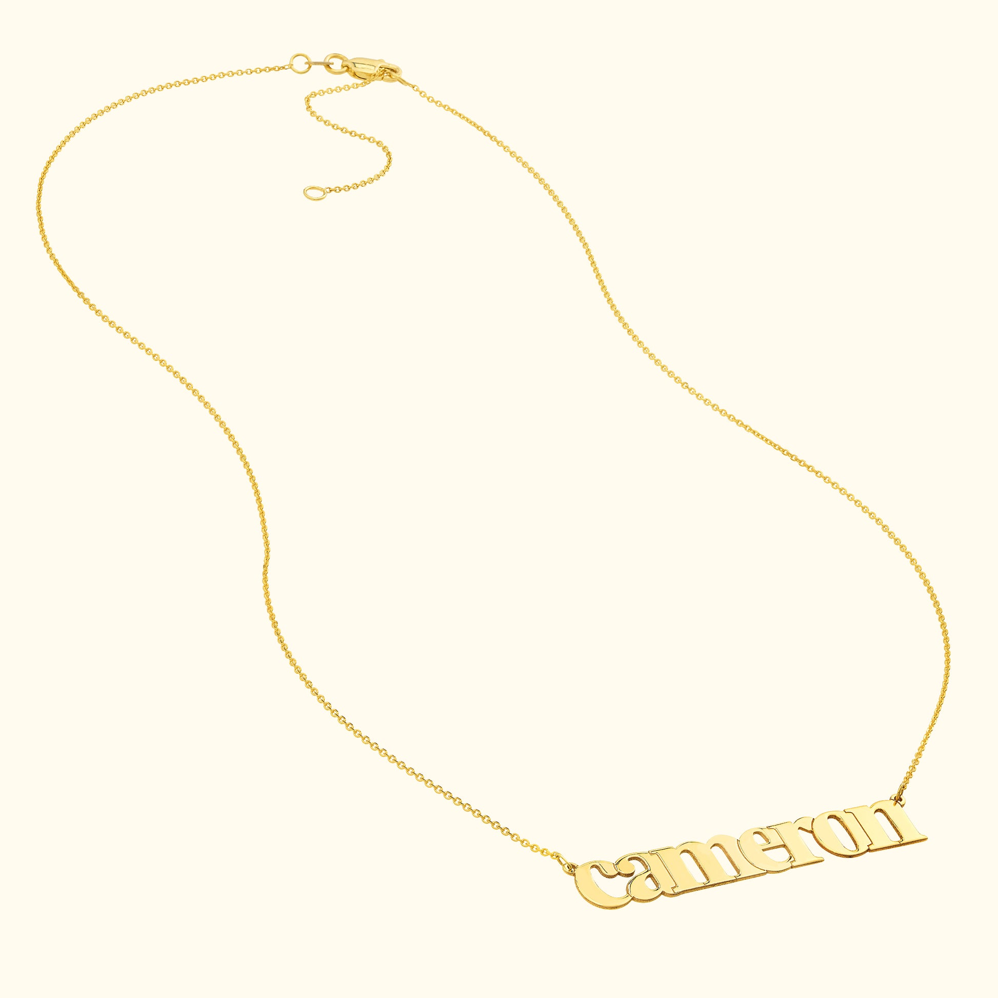 Gold necklace featuring a personalized nameplate that reads "Cameron."