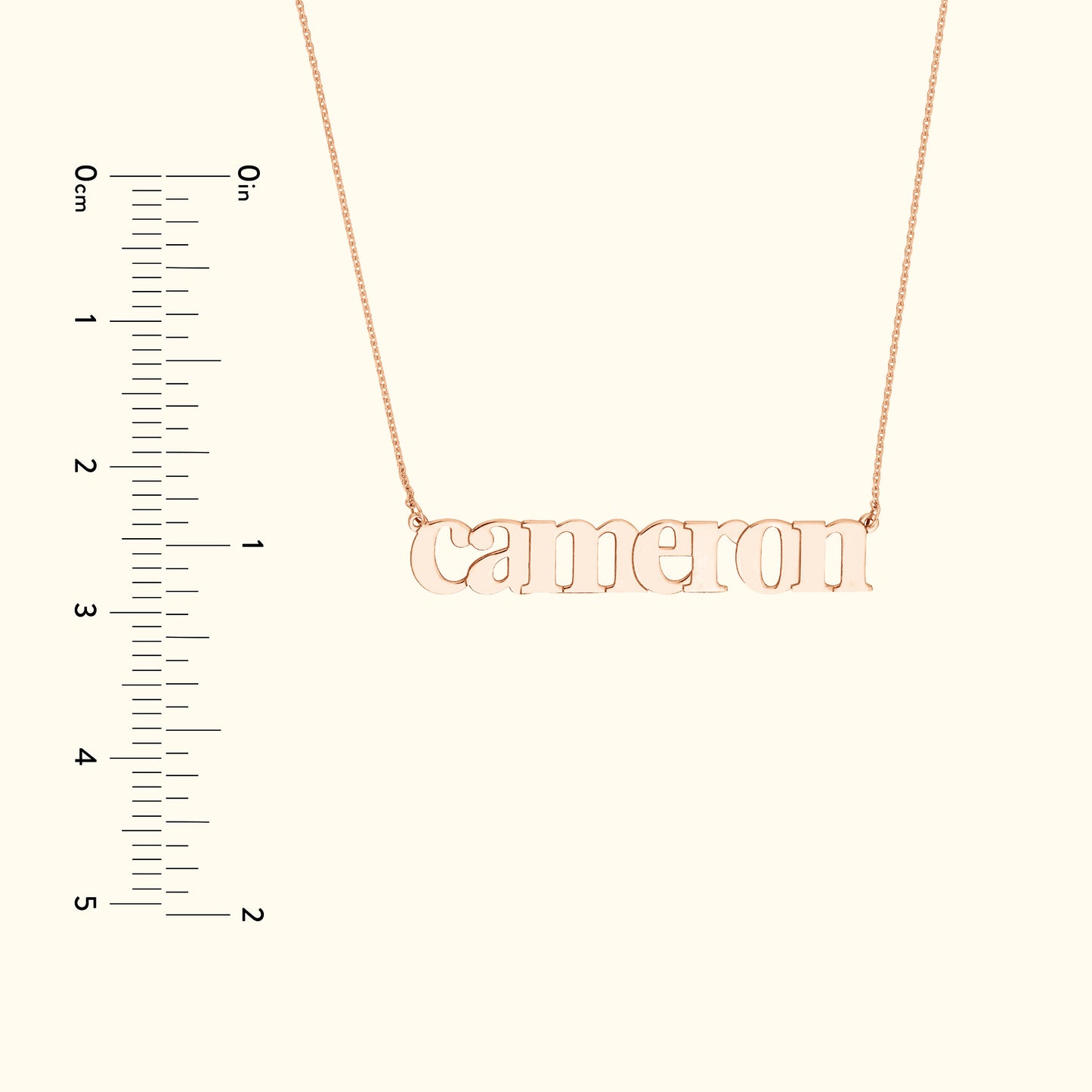 Rose gold name necklace with the word "cameron," displayed against a light background.
