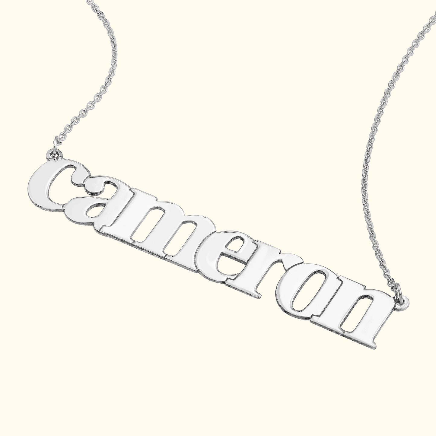 Silver name necklace with the word "cameron" in bold letters.