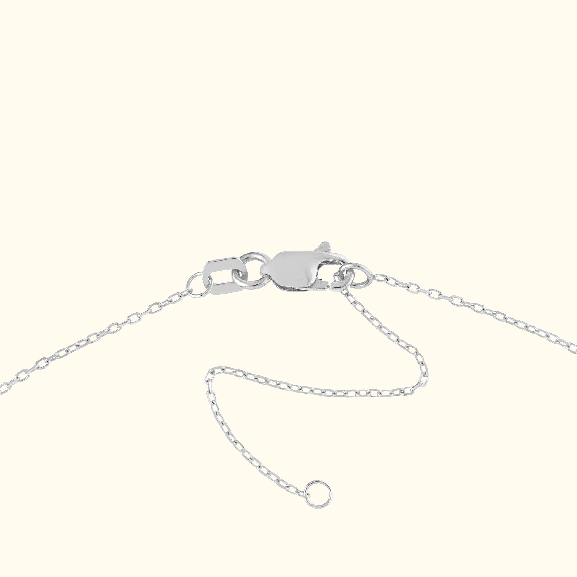 Silver bracelet clasp with a chain, against a neutral background.
