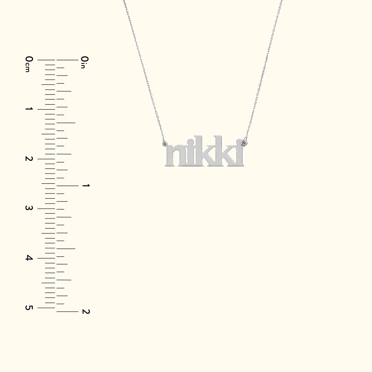 Silver name necklace spelling "nikki" with a simple chain against a light background.