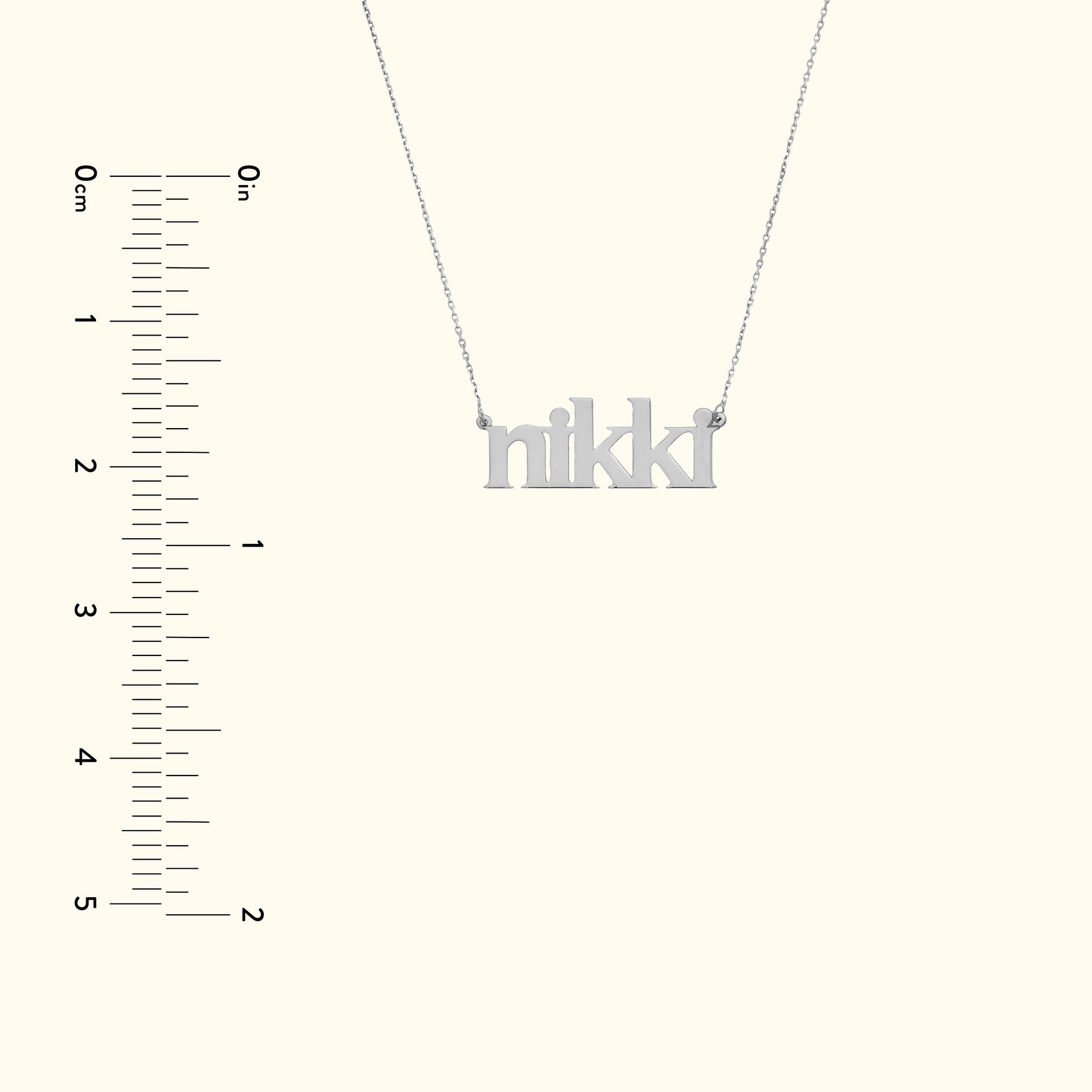 Silver name necklace spelling "nikki" with a simple chain against a light background.