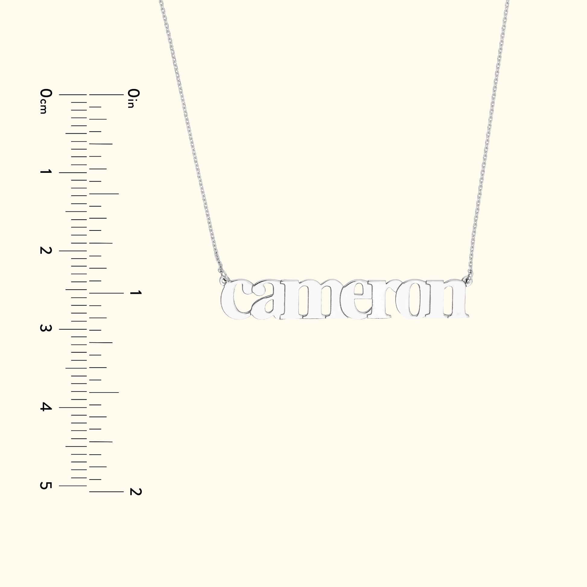 Silver name necklace spelling "Cameron" on a simple chain, with a measuring scale on the side.