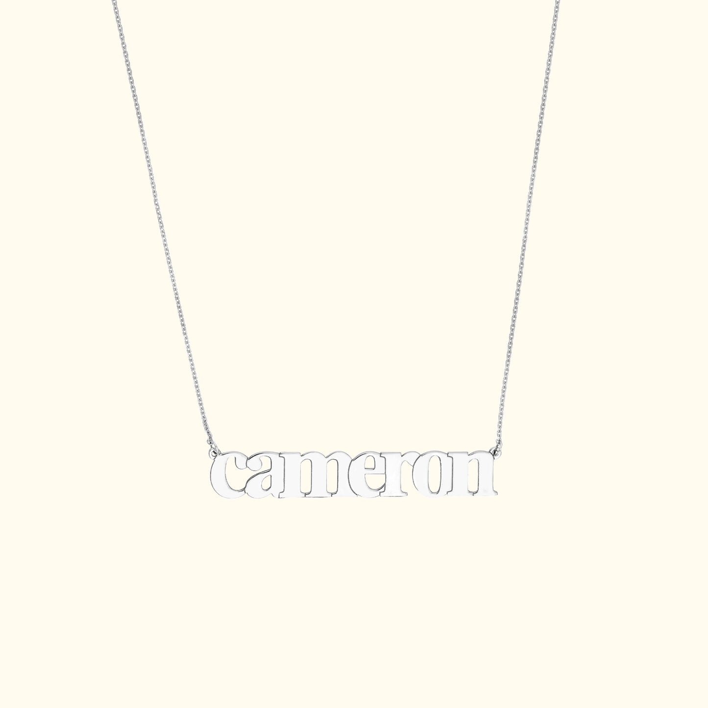 Silver name necklace reading "cameron" on a delicate chain.