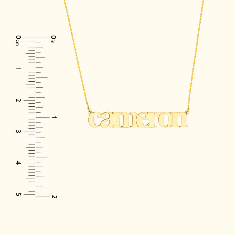 Gold name necklace featuring the name "Cameron" with a ruler for size reference.