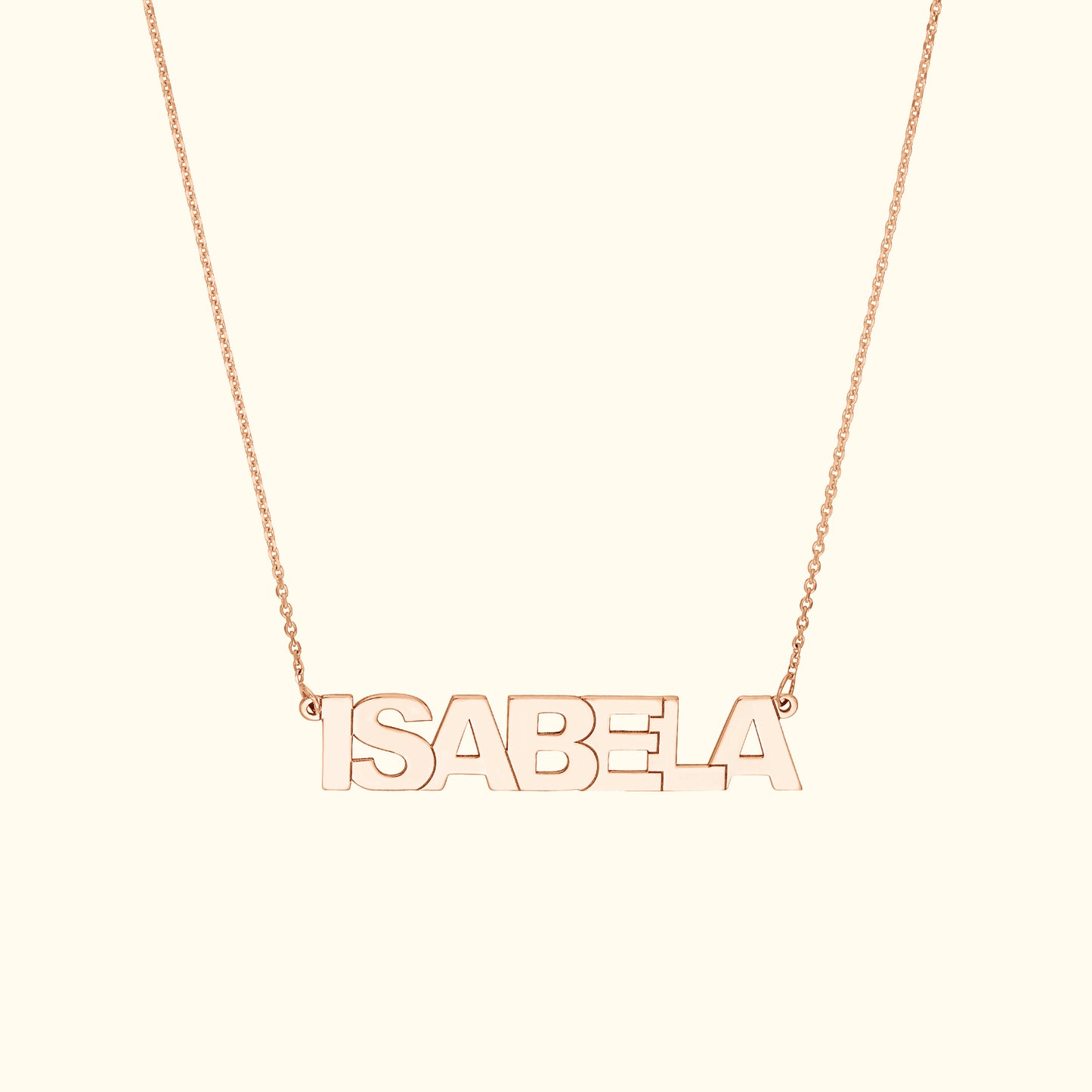 Rose gold name necklace spelling "ISABELA" on a delicate chain.