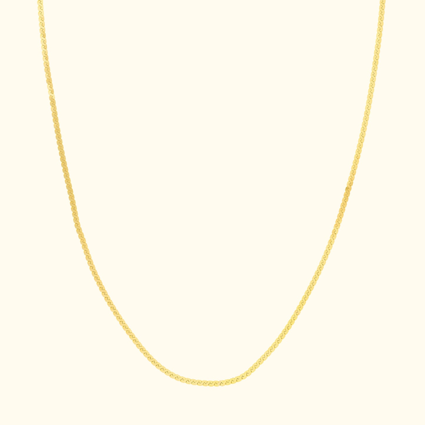 Delicate gold chain necklace with a smooth, subtle design against a light background.