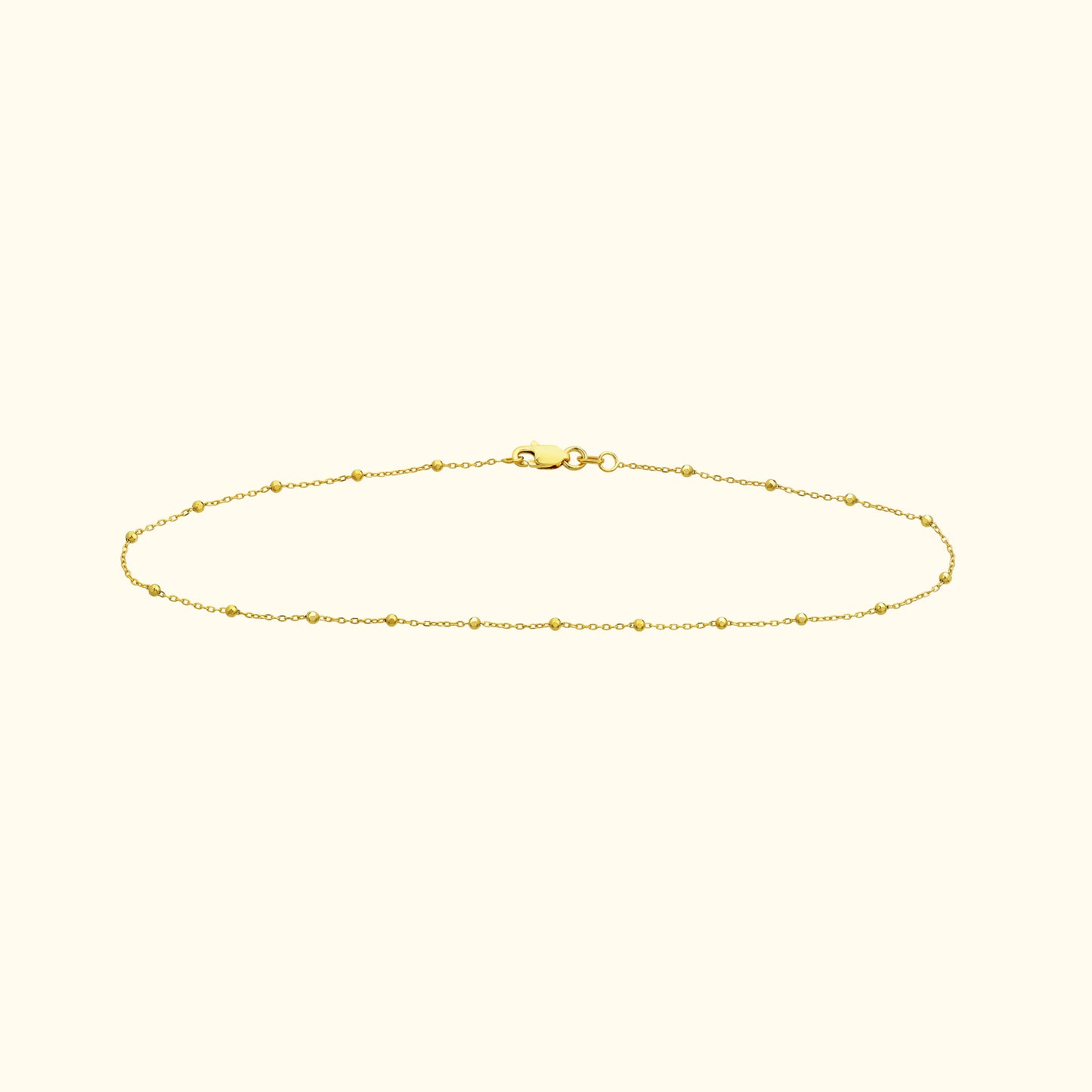 Delicate gold chain bracelet with small bead accents and a clasp.
