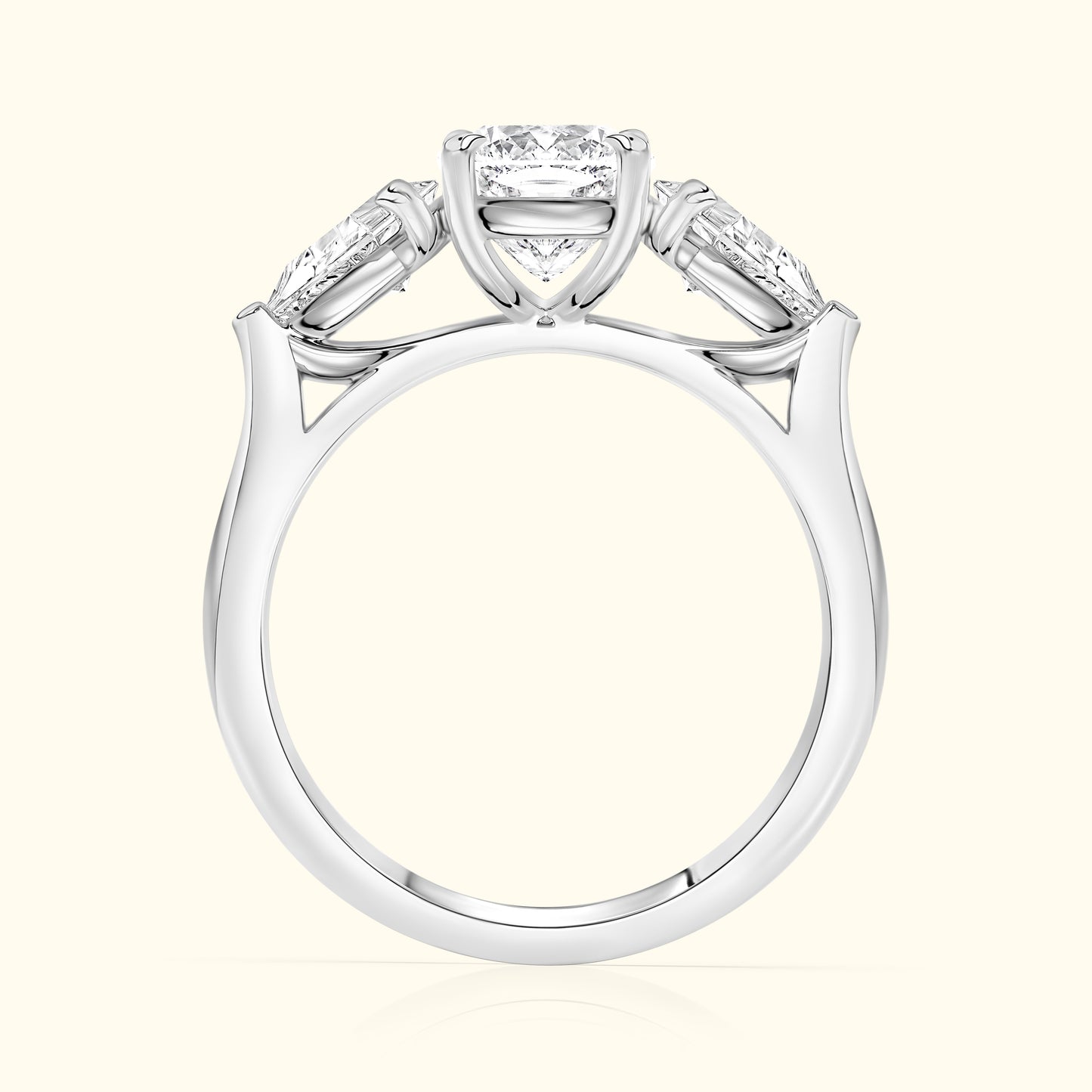 Three-stone diamond engagement ring, featuring a central round diamond with two tapered baguettes on the sides.