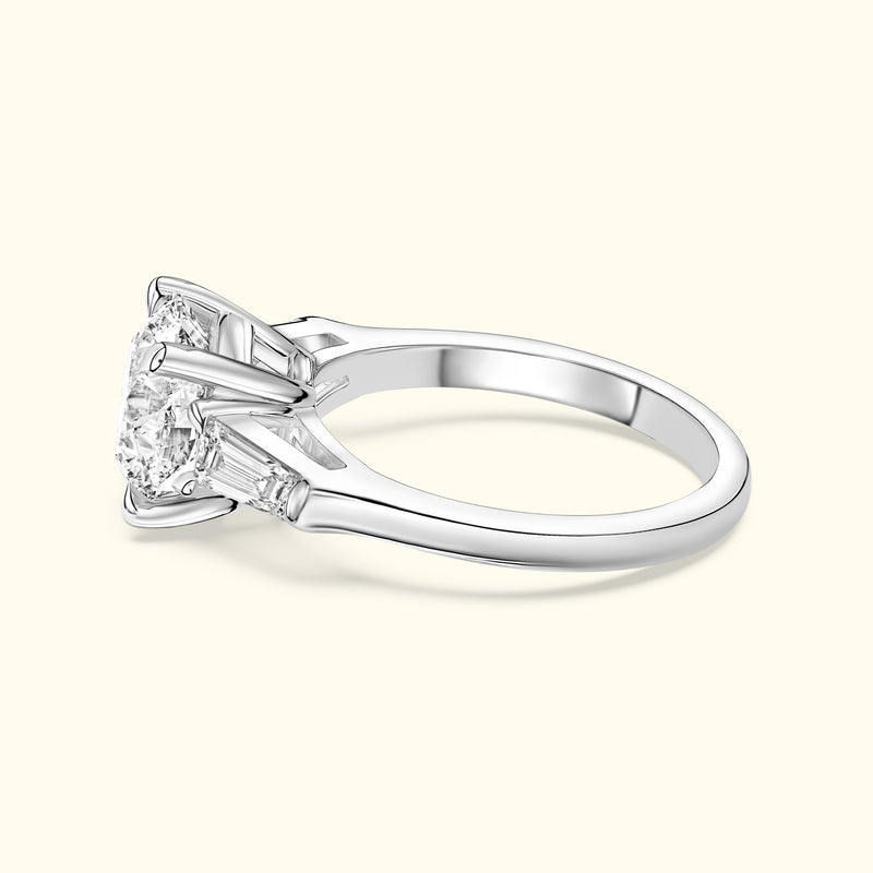 Elegant silver engagement ring featuring a large center diamond and side step-cut diamonds.