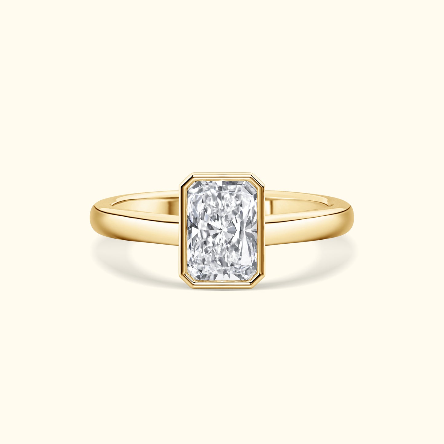 A gold ring featuring a large rectangular diamond in a simple, elegant setting.