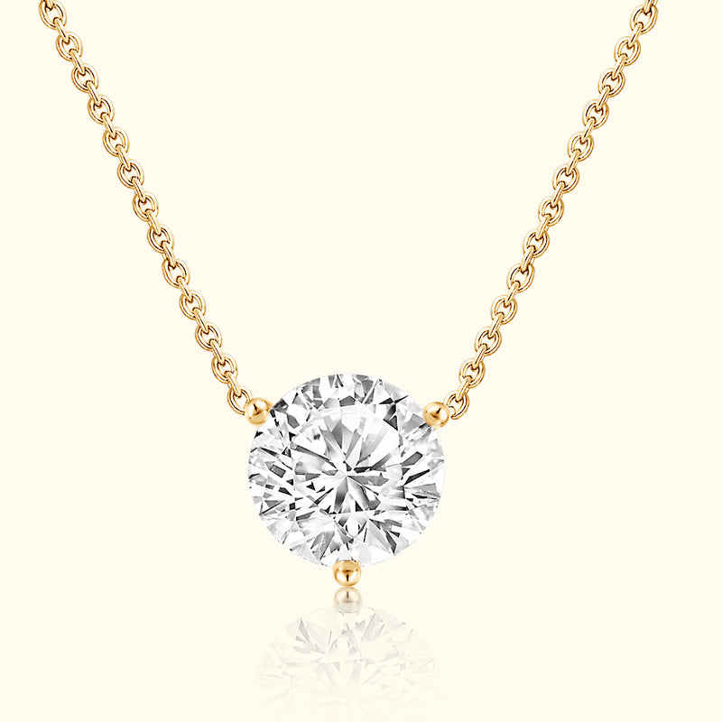 Gold necklace featuring a large, round diamond pendant.