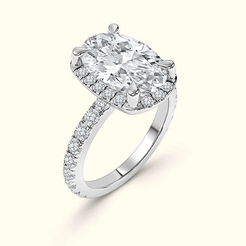 Sparkling oval diamond ring with a halo setting and a paved band.
