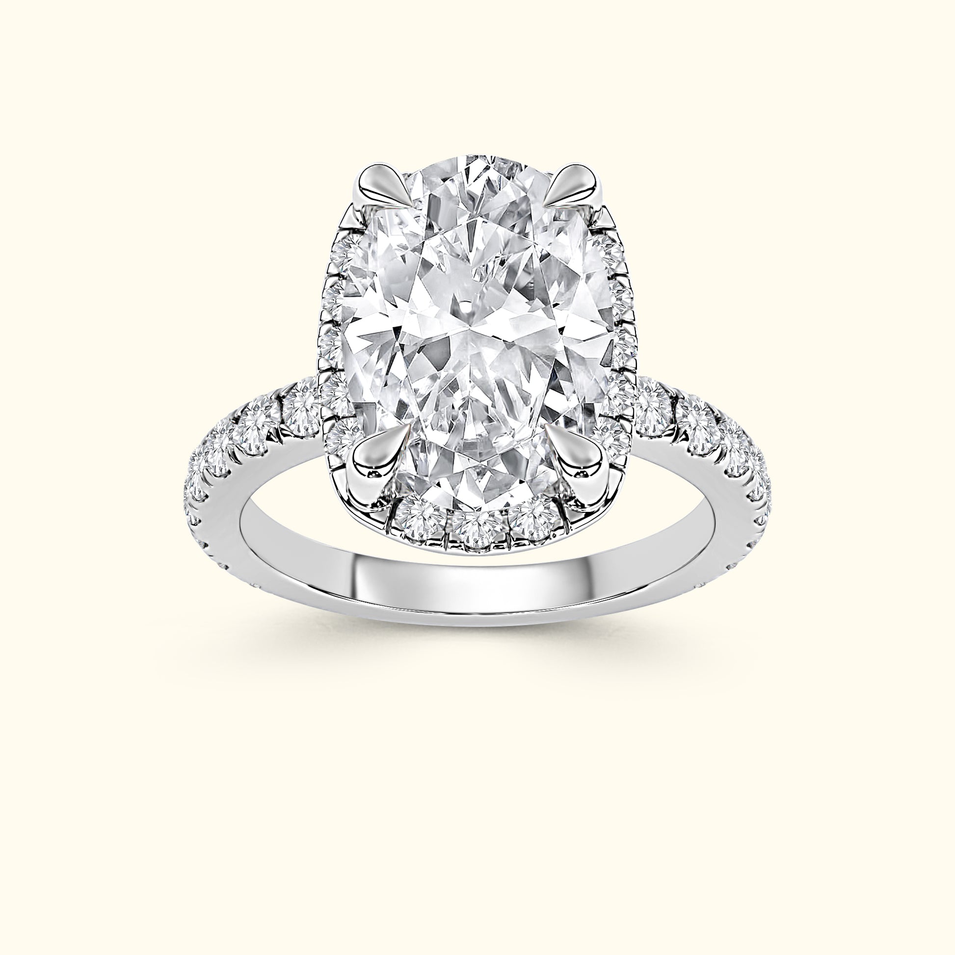 Oval diamond ring with a halo and small diamonds along the band, set in white gold.