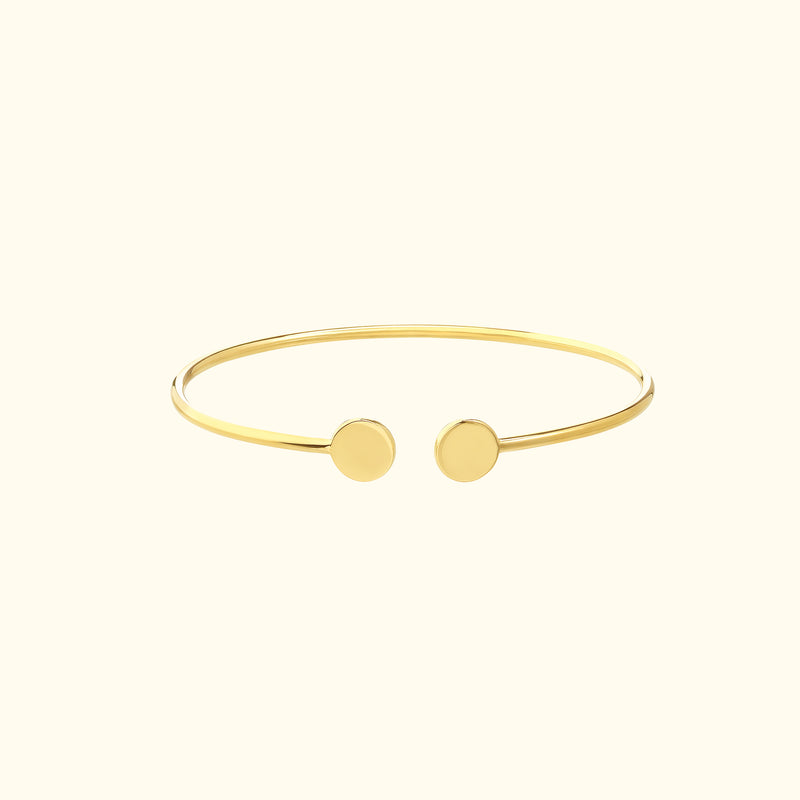 Minimalist gold cuff bracelet with two round ends.