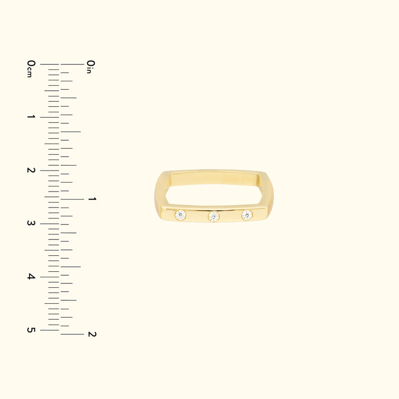 Gold band ring featuring three small diamonds, displayed against a light background.
