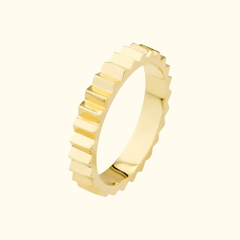 Gold band ring with a textured, stepped design.