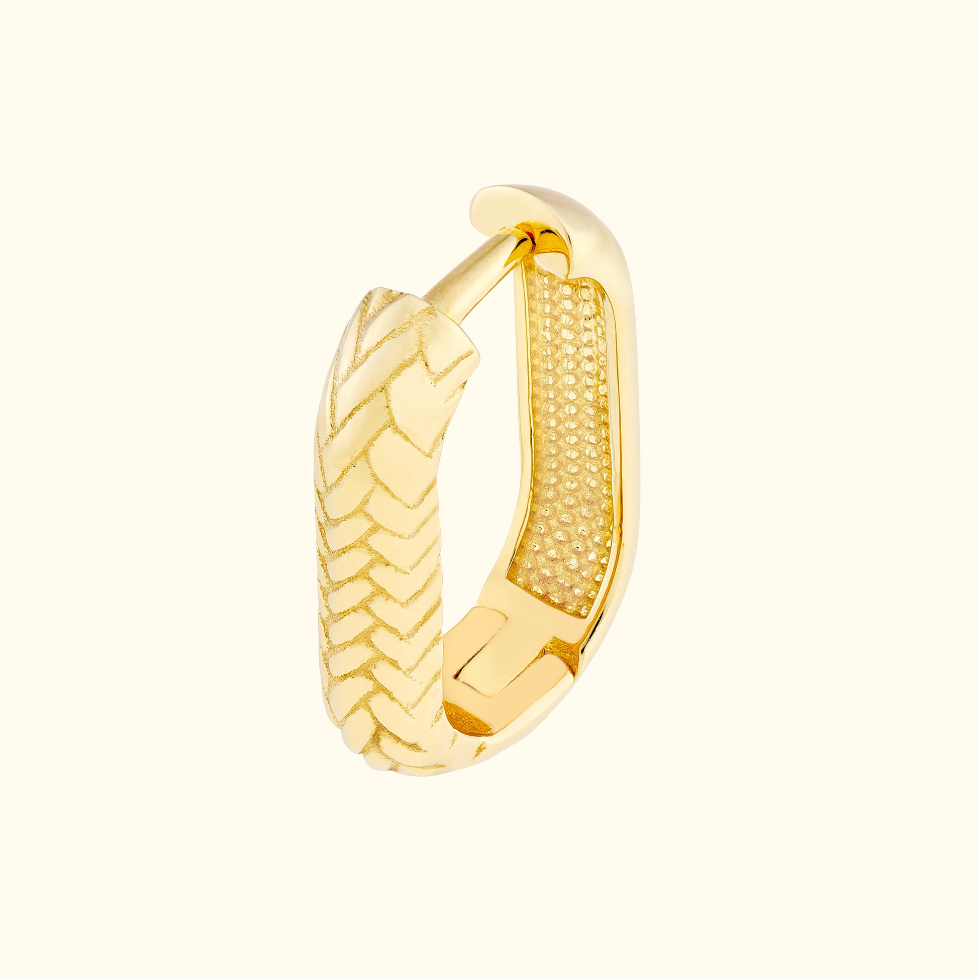 Textured gold hoop earring with a polished finish and decorative detailing.