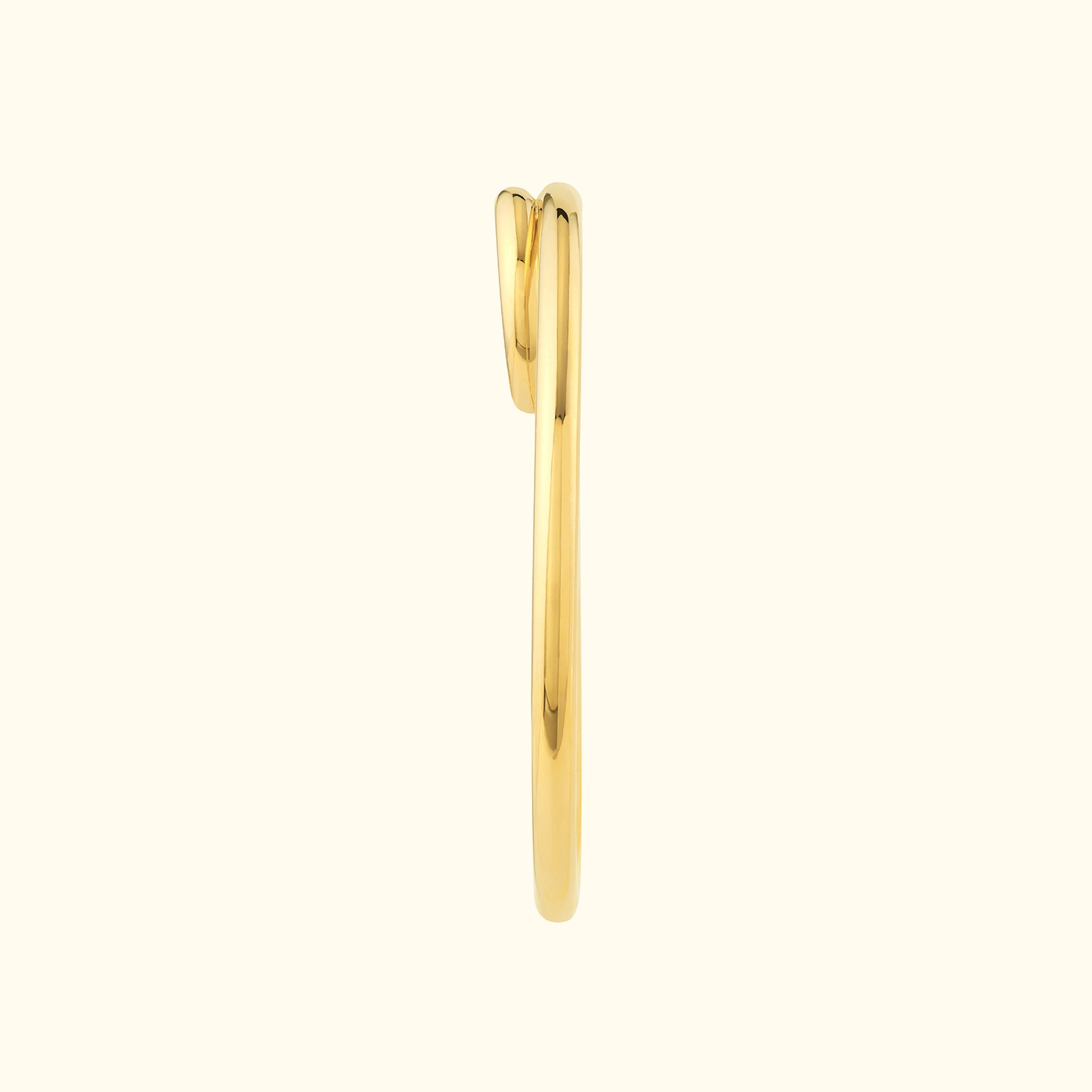 Elegant curved gold ring against a neutral background.