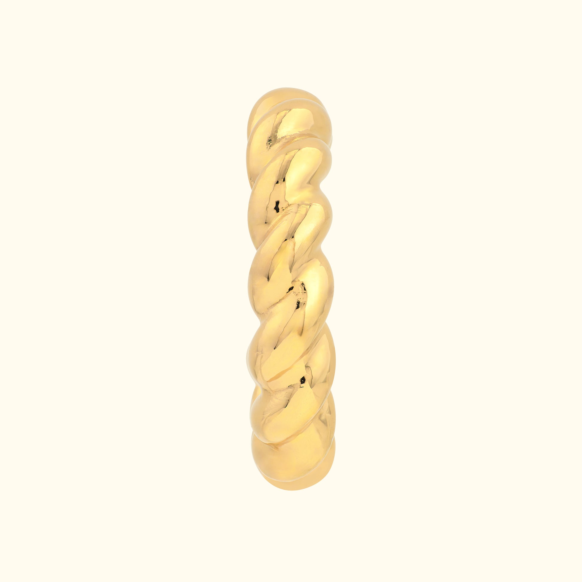 Twisted gold ring with a polished finish on a neutral background.