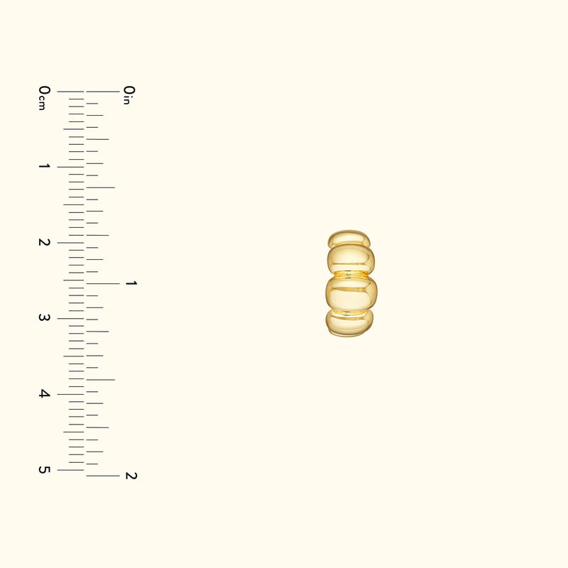 Gold ring with three rounded elements, displayed against a light background.