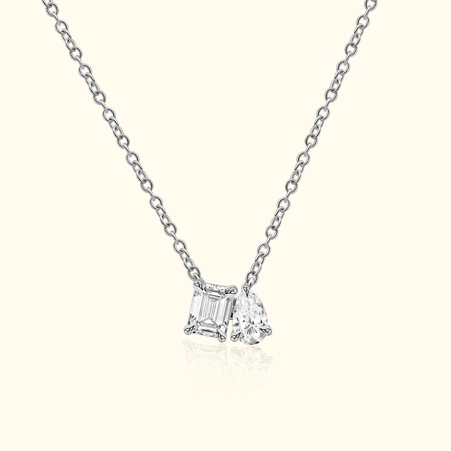 Silver necklace featuring two distinct diamond charms.