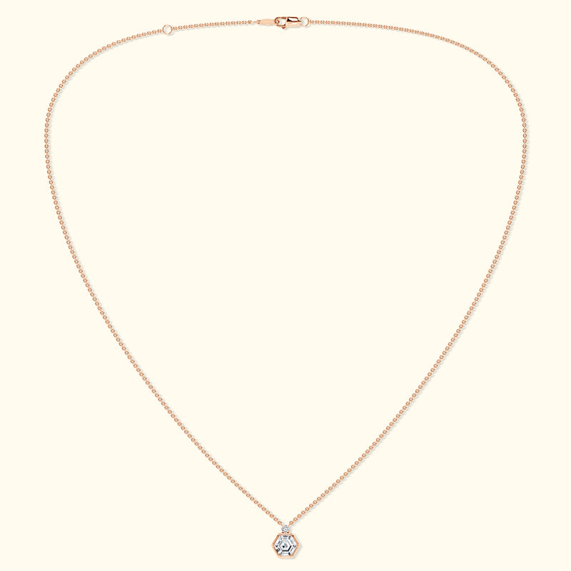 Delicate rose gold necklace featuring a hexagon pendant with a central gemstone.
