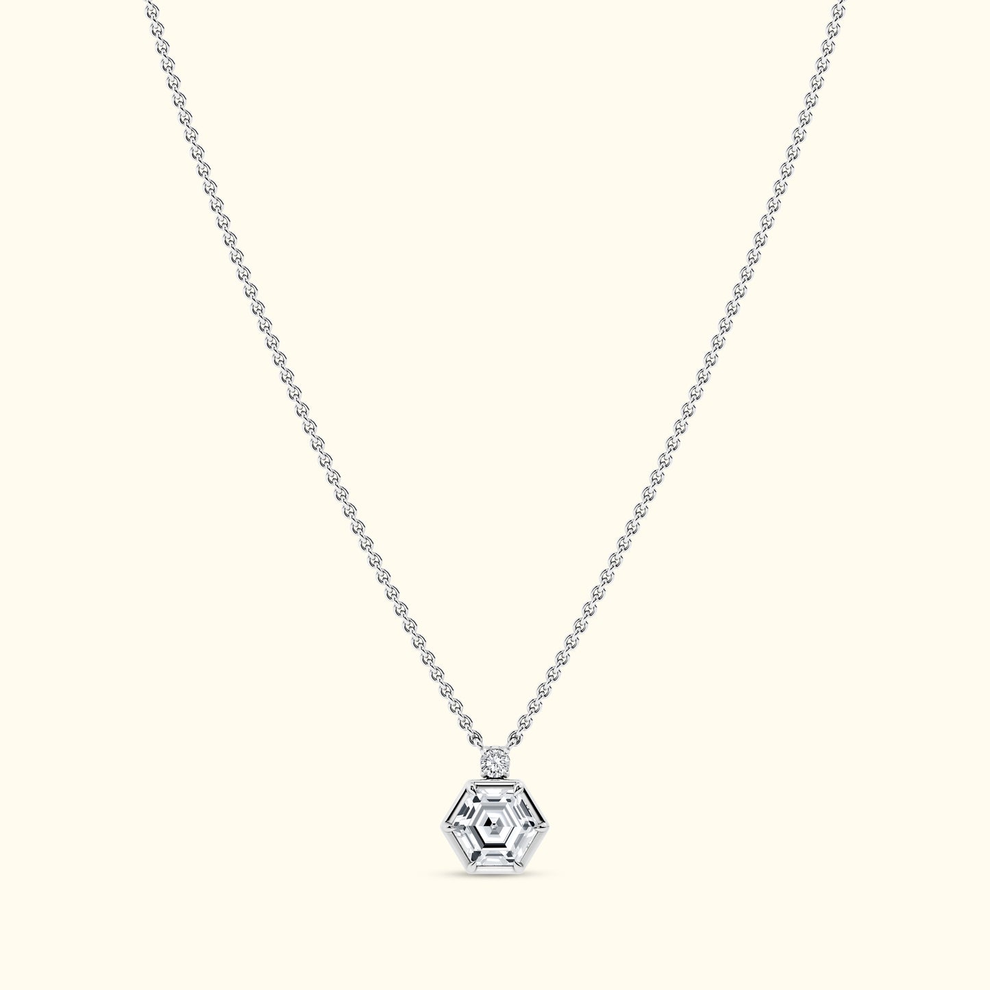 Silver hexagonal pendant on a delicate chain against a light background.