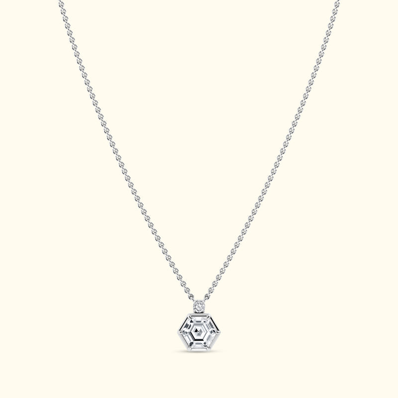 Silver hexagonal pendant on a delicate chain against a light background.