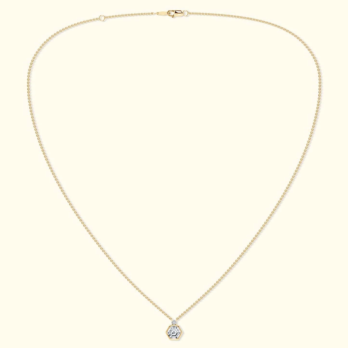 Delicate gold chain necklace with a hexagonal diamond pendant.