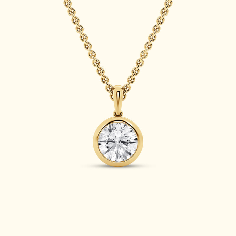 Gold pendant necklace featuring a round, brilliant-cut diamond.