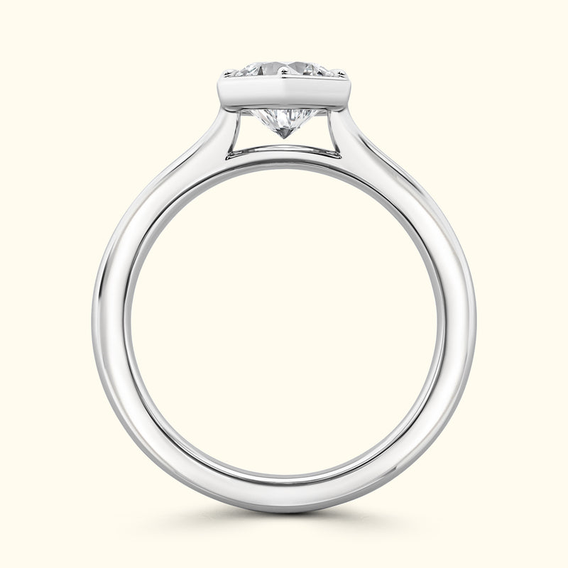 Sleek silver engagement ring featuring a prominent round diamond on a simple band.