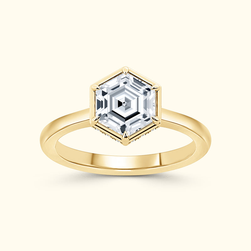Golden ring featuring a hexagonal clear gemstone in a decorative setting.