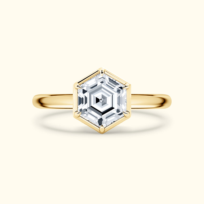 Gold hexagonal ring featuring a sparkling clear gemstone at the center.